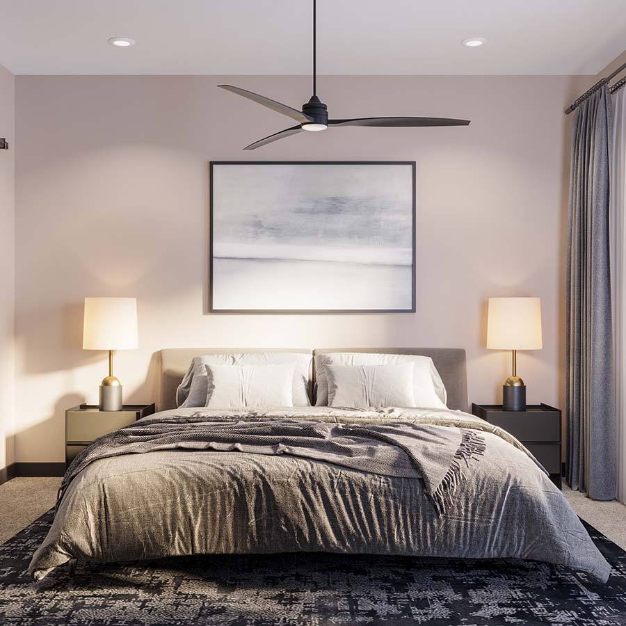 Bedroom with pattern rug, plush bed, bedside tables with lamps, and ceiling fan at Elysium Apartments.